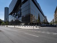 large office building next to a busy street in a city intersection with tall, shiny black buildings