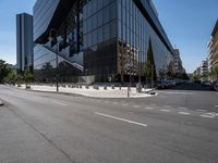 large office building next to a busy street in a city intersection with tall, shiny black buildings