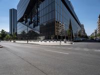 large office building next to a busy street in a city intersection with tall, shiny black buildings