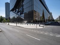 large office building next to a busy street in a city intersection with tall, shiny black buildings