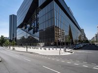 large office building next to a busy street in a city intersection with tall, shiny black buildings