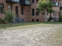 there is a large brown building with stairs in the background and grass in between two buildings