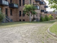 there is a large brown building with stairs in the background and grass in between two buildings