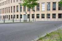 a yellow and black fire hydrant is on the side of a street with a building in the background