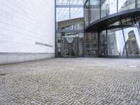 an open building with a stone patio below a circular entrance and glass walling on the sides