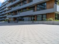 a person is riding down a brick road in front of apartment buildings on a cloudy day