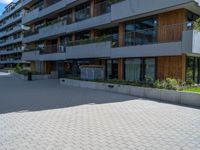 a person is riding down a brick road in front of apartment buildings on a cloudy day