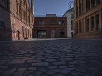 street view of buildings from outside at dusk in old european city with cobblestone pavement