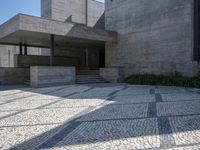there is a very large courtyard with some stairs in front of a building with stone floors