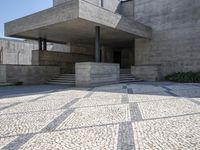 there is a very large courtyard with some stairs in front of a building with stone floors