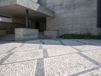 there is a very large courtyard with some stairs in front of a building with stone floors