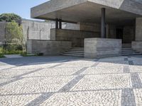 there is a very large courtyard with some stairs in front of a building with stone floors