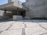 there is a very large courtyard with some stairs in front of a building with stone floors