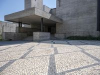 there is a very large courtyard with some stairs in front of a building with stone floors