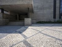 there is a very large courtyard with some stairs in front of a building with stone floors