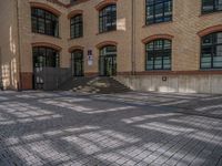 a brick courtyard has steps leading up to it, and a blue umbrella is on the ground