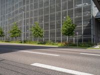 a road leading to a very large building surrounded by tall glass structures and trees in front