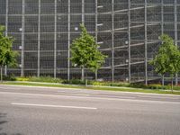 a large building on the side of a street with trees in front of it and traffic lights