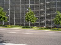 a large building on the side of a street with trees in front of it and traffic lights