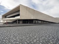 a large building with concrete floors is shown on a cobble stone road in front of it