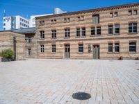 an empty building with two tall brick walls and an open courtyard in front of it