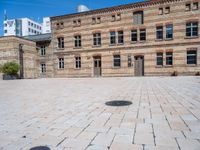 an empty building with two tall brick walls and an open courtyard in front of it