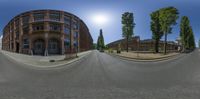 the view from a fish eye lens shows an empty street in front of a red brick building