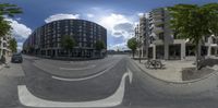 there are two bicycles and one car in the city street with tall buildings in the background