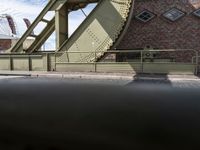 an old bridge has a clock and other things in the background from the pavement on the road