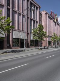 two traffic lights are on and are mounted next to a street lined with tall buildings