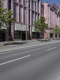 two traffic lights are on and are mounted next to a street lined with tall buildings