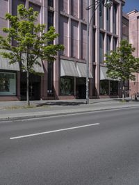 two traffic lights are on and are mounted next to a street lined with tall buildings