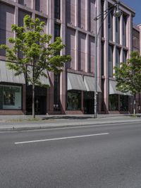 two traffic lights are on and are mounted next to a street lined with tall buildings