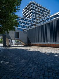 the building has several different angles on it, in varying colors and shapes with brick and concrete floors