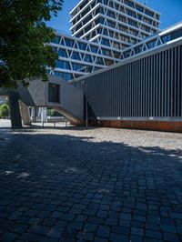 the building has several different angles on it, in varying colors and shapes with brick and concrete floors