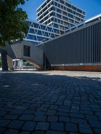 the building has several different angles on it, in varying colors and shapes with brick and concrete floors