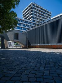 the building has several different angles on it, in varying colors and shapes with brick and concrete floors