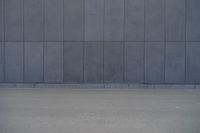 a person wearing a face mask walking across an empty street with a skateboard in the foreground