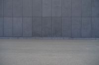 a person wearing a face mask walking across an empty street with a skateboard in the foreground