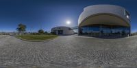 an empty circle with the sun shining and building in the background at the end of it