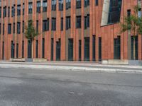 a building with some concrete blocks and a sidewalk in front of it and a sign for the parking area