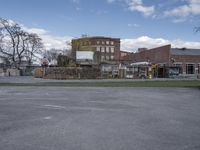 there is a empty parking lot and an old building in the background, with a clock tower at the bottom of it