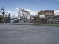 there is a empty parking lot and an old building in the background, with a clock tower at the bottom of it