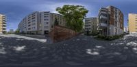 four fish eye photo of an area near several large buildings in the city center of a small town