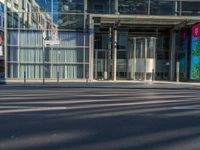 the sunlight reflects from several windows in a large building onto the street from outside the building