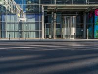 the sunlight reflects from several windows in a large building onto the street from outside the building