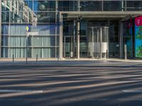 the sunlight reflects from several windows in a large building onto the street from outside the building