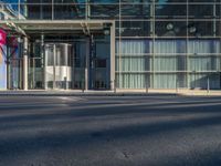 the sunlight reflects from several windows in a large building onto the street from outside the building