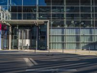 the sunlight reflects from several windows in a large building onto the street from outside the building