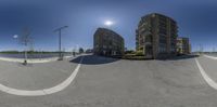 a 360 degree view of an empty parking lot in front of a building on a sunny day